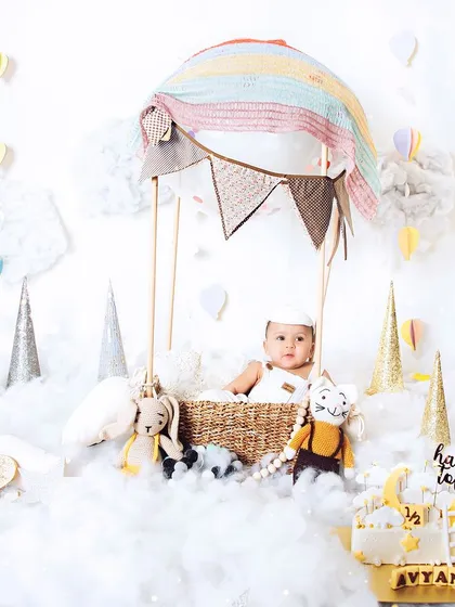 Halfway to one. This adorable hot air balloon setup is perfect for a six-month milestone shoot, creating a dreamy and whimsical atmosphere.