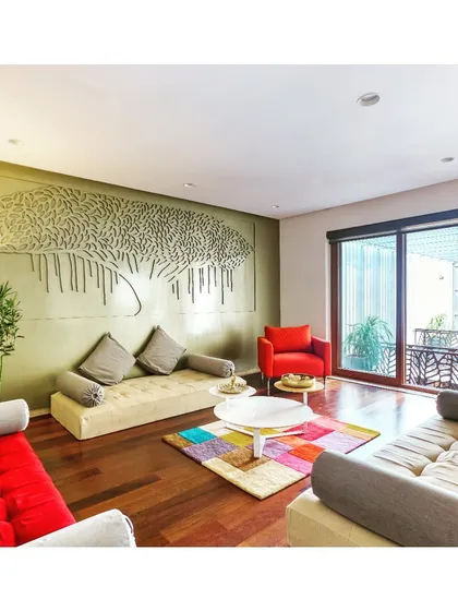 In this family living space, we commissioned a custom "Tree of Life" wall art piece to serve as the room's anchor. The design combines earthy tones with pops of color in the furnishings to create a warm, vibrant, and personalized environment for the family to gather.