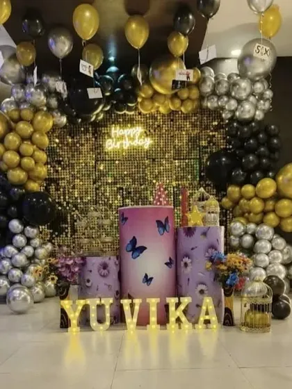A black, gold, and silver theme with a sequin wall and butterfly-themed pedestals.