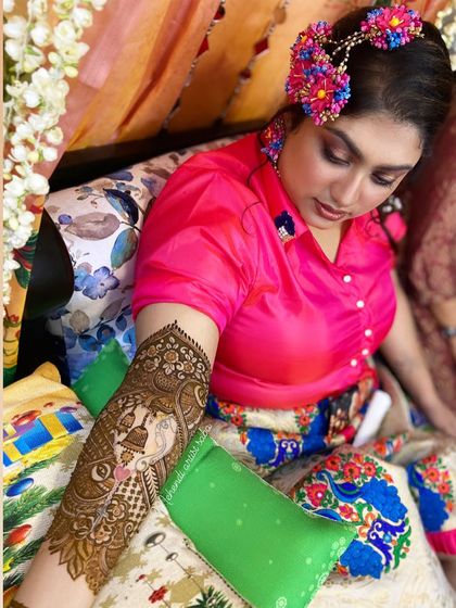 A beautiful shot of a bride with a custom portrait mehendi on her arm. The design depicts a traditional bride in her palanquin (doli).