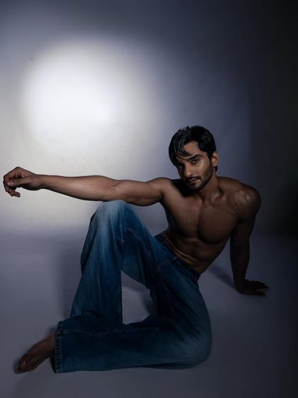 A dynamic, floor-based pose that highlights the model's physique and ability to create interesting shapes.