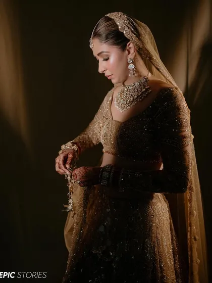 A classic portrait pose with beautiful, soft lighting. This image highlights the intricate embroidery on the sleeves of her lehenga and the delicate details of her henna.