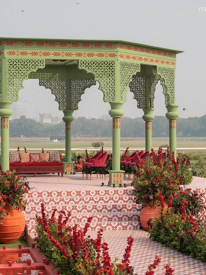 The mandap stage with its custom-tiled floor and rich red seating. The design combines traditional patterns with a bold, modern color sensibility.