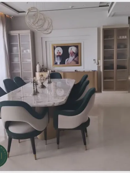 We crafted this dining area to exude refined grace. The centerpiece is a substantial marble-top dining table, surrounded by two-tone upholstered chairs in teal and cream, offering both exceptional comfort and a striking visual statement for memorable dinners.