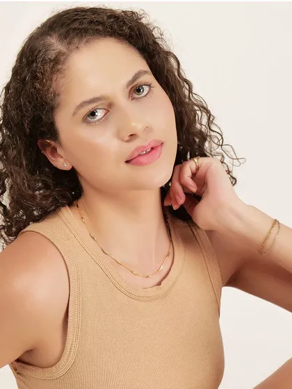 A detailed close-up on the neckline of the tank top and the model's accessories, showing our attention to every element of the shot.