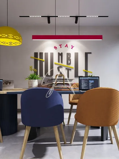 A glimpse into a modern office meeting room where creativity thrives. We used bold color accents, including a vibrant red light fixture and multi-colored chairs, against a backdrop of motivational wall graphics to create an energetic and collaborative workspace.