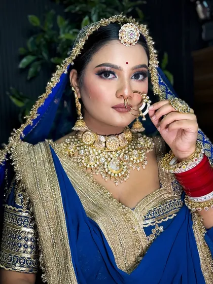 I love creating unique looks that honor tradition. Here is a stunning Rajputi bridal look, featuring a bold blue lehenga with traditional gold jewelry and makeup that highlights the bride's regal elegance.