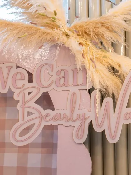 The "We Can Bearly Wait" sign, beautifully crafted and accented with pampas grass, served as the centerpiece of the photo backdrop.