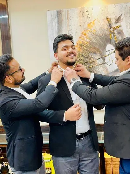 Two seniors joining in to help a new advocate with his bands. This shows our collective commitment to welcoming and supporting new members of the profession.