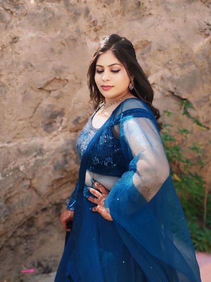 This pose highlights the subtle shimmer on her eyelids and the overall dewy finish of the makeup.