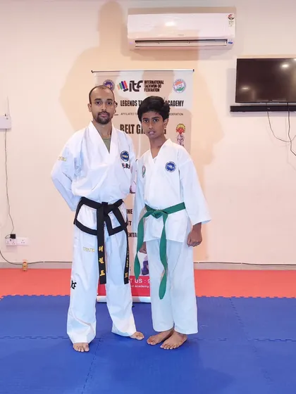 Posing with a student after his promotion. His hard work and focus during training have clearly paid off.