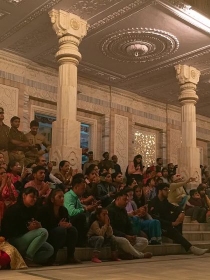 Candid shots of the priests and the large crowd of devotees during the Maha Aarti at JK Temple, capturing the community and shared experience of the event.