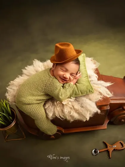 My sessions can be as creative as you wish. Here, a sweet sleeping baby dreams of adventure in a vintage-style truck prop, complete with a cozy pillow and a touch of greenery. This shows how we can incorporate fun themes into your newborn's first photoshoot.