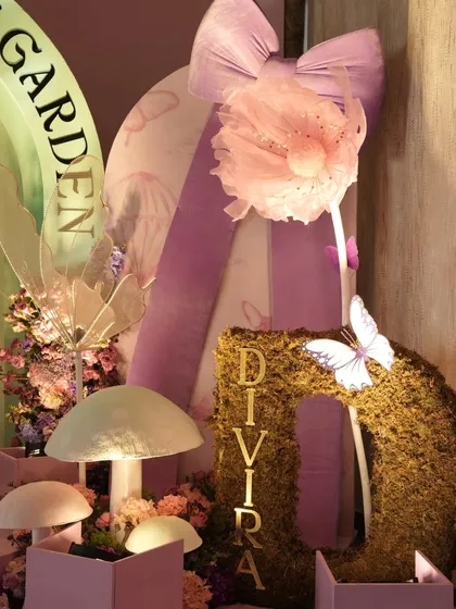 A close-up of the enchanted garden decor, showing a moss-covered initial, glowing mushrooms, and delicate fairy wings. These details bring the magical theme to life.