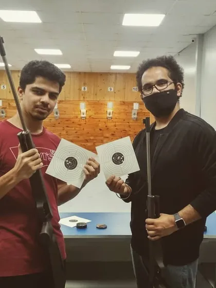 Two of our guests proudly display their target sheets after a successful session. The satisfaction of seeing your shots group together is a key part of the experience we love to share.