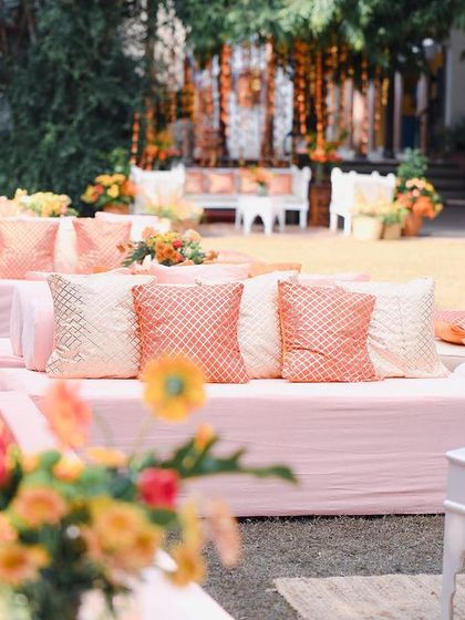 A view of the low diwan seating, styled with custom-printed cushions in peach tones. This comfortable and chic setup was perfect for guests to relax and get their mehendi done.