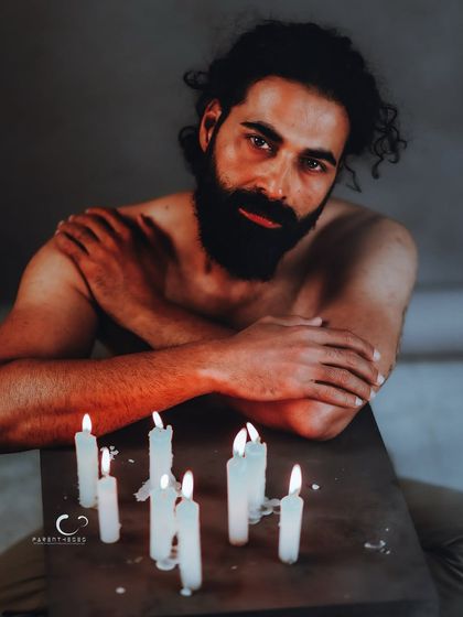 Another moment from the candle series, this time with a more direct and vulnerable expression. The warm light of the flames creates an intimate and powerful mood.