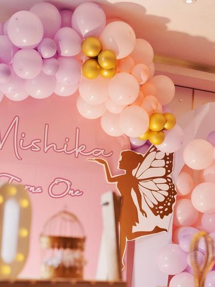 A close-up of the neon sign and balloon arch from Mishika's party. The soft glow of the "Mishika Turns One" sign adds a modern and personal touch to the backdrop.
