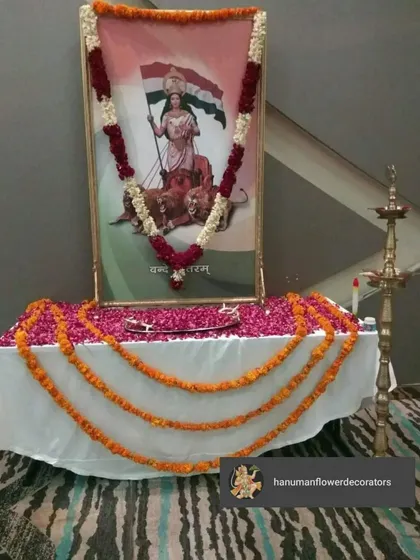 A simple yet respectful setup for Independence Day celebrations in an office. We decorated a portrait of Bharat Mata with a garland made of red and white flowers and draped the table with marigold strings.