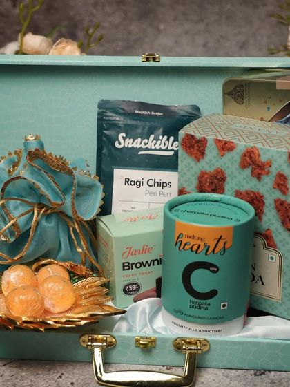 This beautiful turquoise-themed Diwali hamper is perfect for someone who loves color. It includes a variety of snacks and sweets, presented in a reusable trunk-style box.