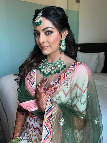 Serving bridal glam for a Mehendi ceremony with ombre eyes, rosy cheeks, and the perfect pink pout. The green jewelry adds a beautiful contrast to the look.