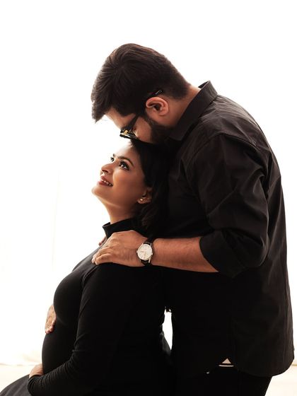 A tender moment between partners against a clean, high-key background. The focus is all on their loving gaze.