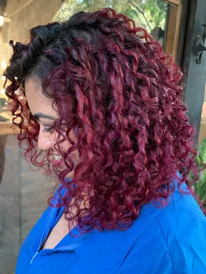 A side view of the 'Pomegranate Sangria' curls, showing how the color and cut work together to create a stunning look.