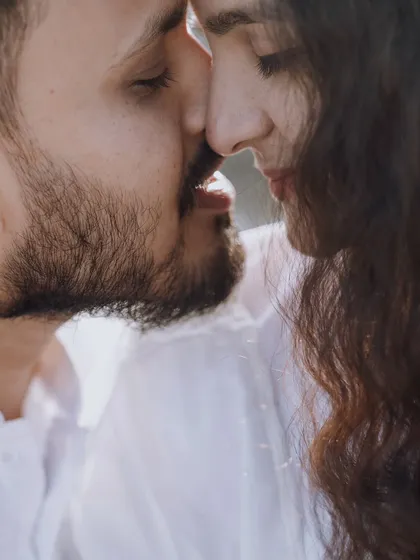 An intimate close-up capturing a near-kiss, full of anticipation and emotion. The soft lighting enhances the romantic and candid feel of the moment.
