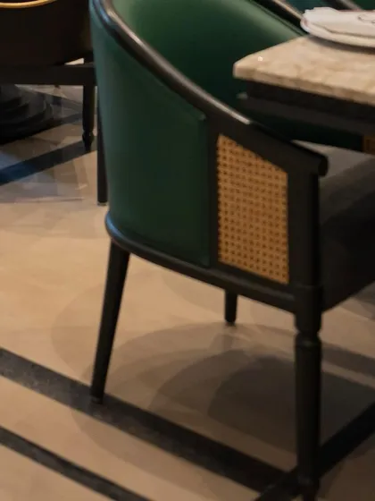 A close look at one of our custom chairs for Begeterre, featuring a beautiful combination of emerald green upholstery and cane work. This is the level of detail we bring to every commercial project.
