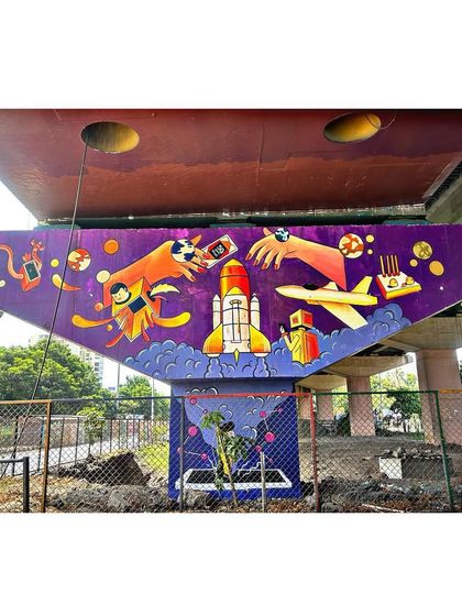 A public art project painting a bridge pillar with a theme of technology and imagination. This mural features a rocket, planets, and creative hands, turning infrastructure into art.