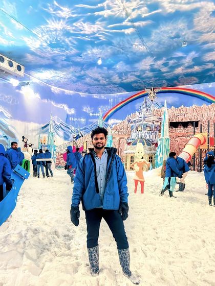 The main hall of Snow City, filled with various snow attractions and a colorful backdrop.