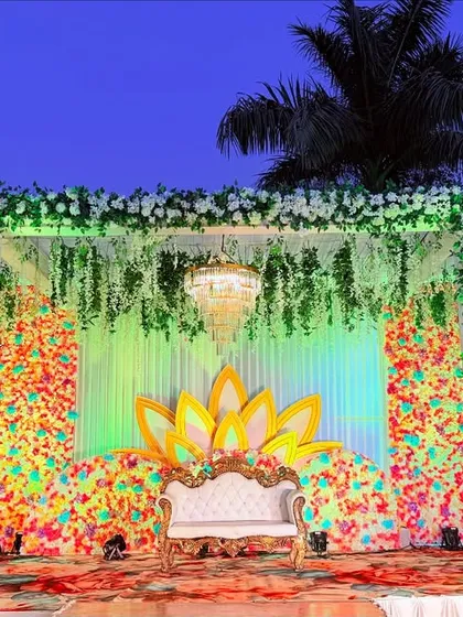 A beautiful stage with a frame of white flowers and a backdrop of colorful florals, creating a vibrant and celebratory look.