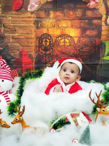 Jingle bells and baby smiles. Our Christmas-themed shoot is perfect for the holidays, with a Santa suit, snowman, and a cozy fireplace backdrop.