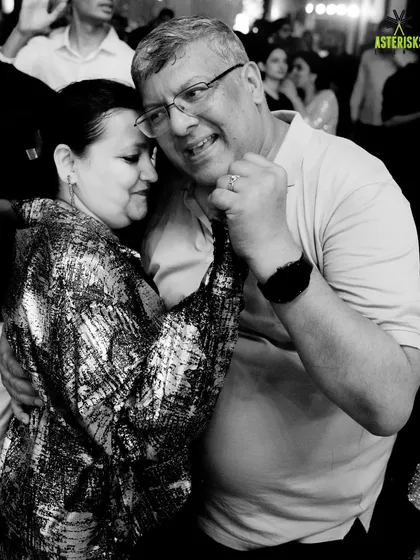 A beautiful black and white shot of a couple dancing, capturing a timeless, joyful moment from the Sangeet night.