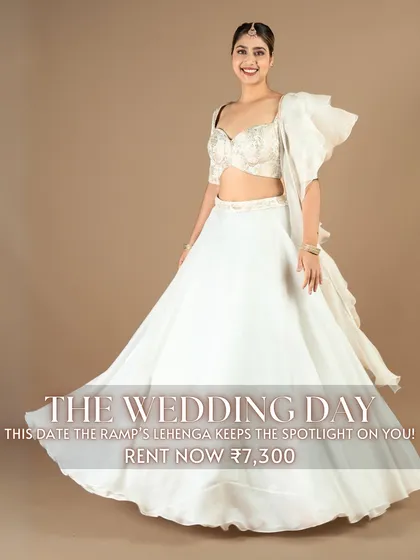 For 'The Wedding Day', this white lehenga with a unique one-shoulder ruffled blouse keeps the spotlight on you. It's an elegant and contemporary choice for a modern wedding ceremony or reception.