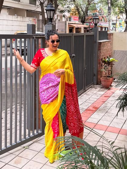 Another angle of the beautiful bandhani saree, this time with a playful, happy expression. It captures the joy and confidence that comes from wearing a beautiful traditional garment.
