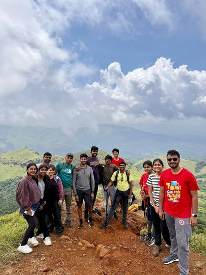 From strangers to a soul tribe. This group photo at a summit, with clouds below, captures the magic of our trek mates. These are the bonds that outlive the mountains.