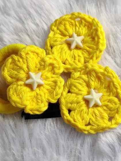 A cute set of yellow floral hair accessories, including a scrunchie and clips, all featuring a sweet star-shaped bead in the center.