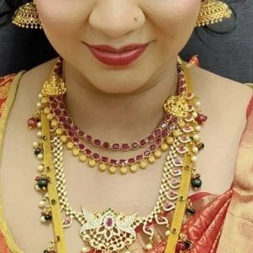 This close-up focuses on the lip color and necklace details, demonstrating how makeup is chosen to complement the client's jewelry and skin tone.