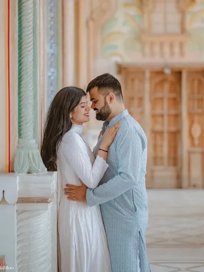 An intimate embrace within the painted archways of Patrika Gate. This close-up shot focuses on the couple's connection, with the vibrant background softly framing their romantic moment.