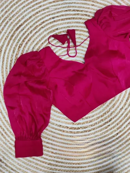 The organza balloon sleeve blouse in a vibrant rani pink.