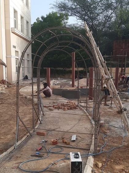 The rebar framework for a garden archway being assembled on-site. This shows the initial steps of creating custom metalwork features.