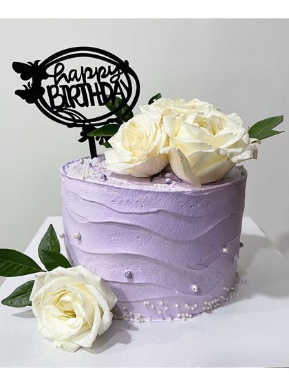 A half-kg tall cake with purple textured frosting and fresh white roses. This design is simple, elegant, and perfect for any celebration.