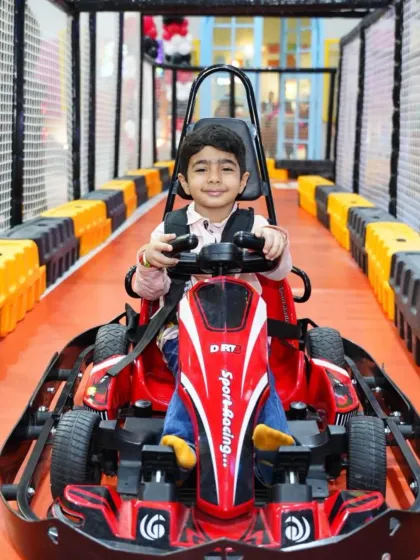This young racer is all smiles and ready to hit the track in his red go-kart. The excitement of our racing zone is a huge draw for kids.