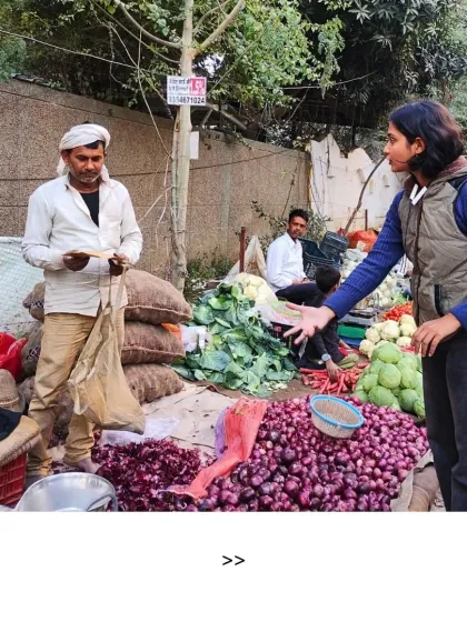 Change starts with a conversation. Here, one of our volunteers talks to a local vegetable vendor about the impact of single-use plastic bags, encouraging him to ask customers to bring their own cloth bags. This is grassroots action in its truest form.