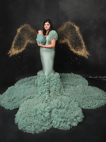 An angel watching over her baby. With digitally added golden wings, this portrait of a mother holding her child is truly magical and symbolic.