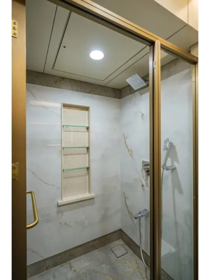 This bathroom design features a beautiful gold-finished vessel sink that adds a touch of glamour. The backlit mirror and clean, white vanity complete the elegant and modern look.