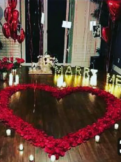 This is the ultimate romantic gesture for a proposal. I create a large, beautiful heart on the floor using hundreds of rose petals, surrounded by the warm glow of candles and illuminated "MARRY ME" letters for a truly breathtaking moment.