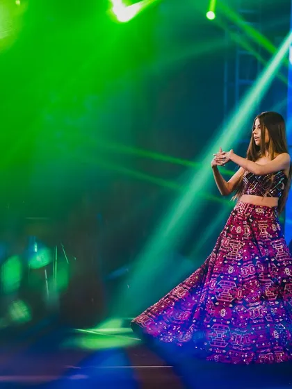 This picture is testimony to our mission of spreading the joy of dancing, one wedding at a time. The pure happiness on the performer's face under the vibrant stage lights is exactly what we strive for.