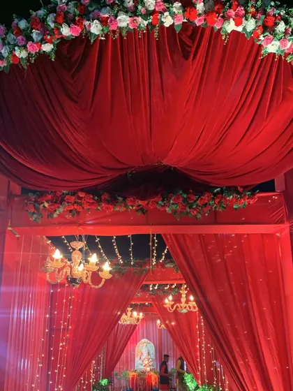 The top of the entrance arch, featuring heavy red velvet drapes and a thick border of red and white flowers. This creates a very grand and royal first impression.